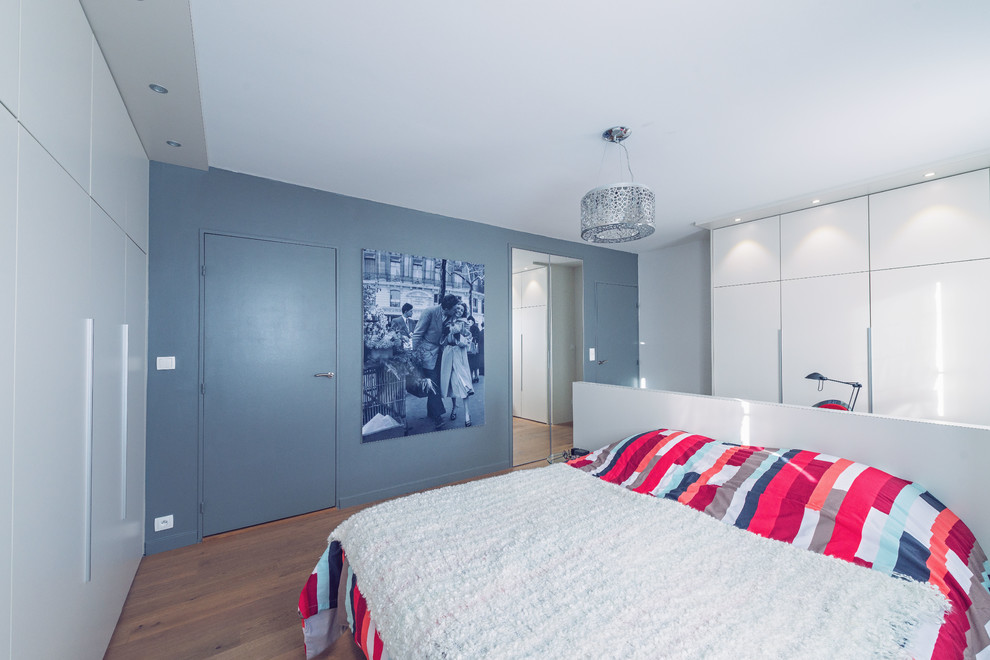 Imagen de dormitorio principal contemporáneo grande con paredes beige y suelo de madera clara