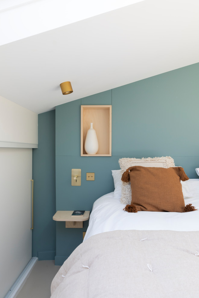 Idée de décoration pour une grande chambre parentale design avec un mur bleu, sol en béton ciré et un sol beige.