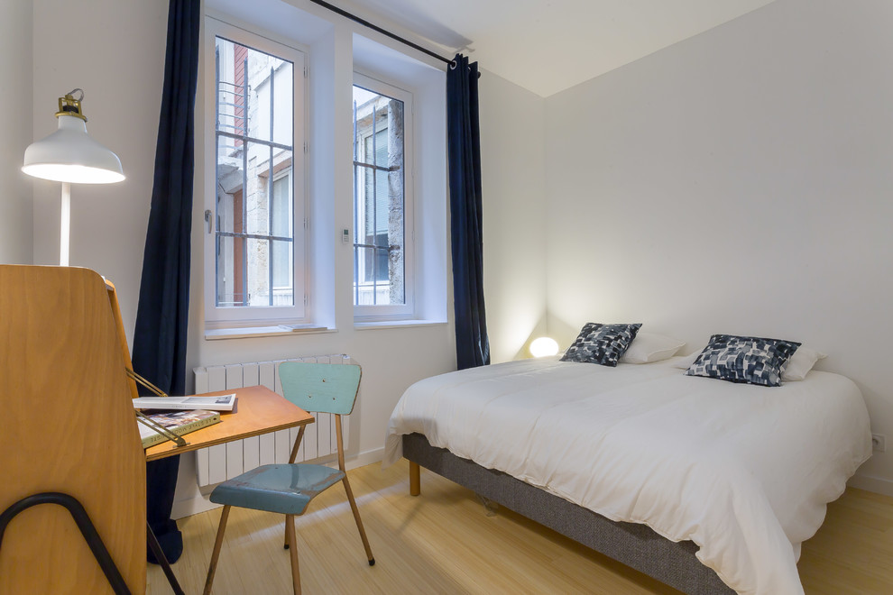 Cette image montre une chambre d'amis nordique avec un mur blanc, parquet clair et un sol beige.