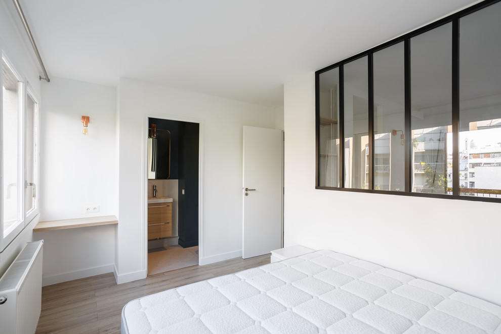 Aménagement d'une chambre parentale scandinave de taille moyenne avec un mur blanc, parquet clair, aucune cheminée et un sol beige.