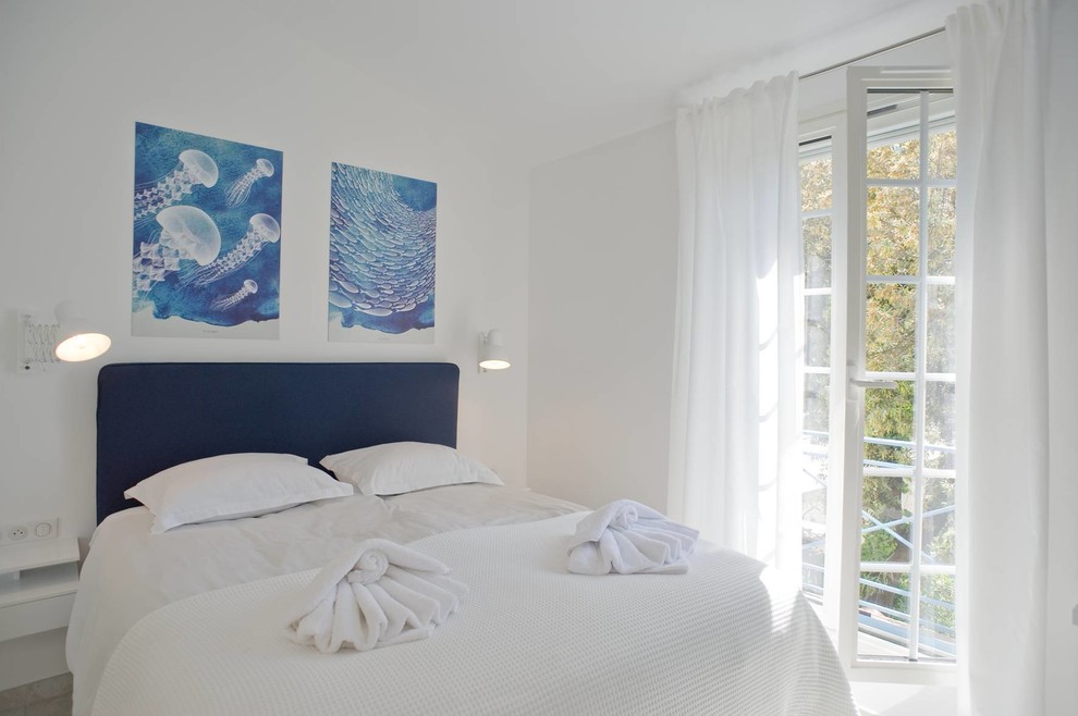 Inspiration pour une chambre parentale méditerranéenne de taille moyenne avec un mur blanc, un sol en carrelage de céramique et un sol gris.