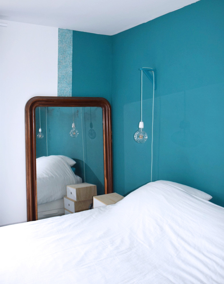 Foto de dormitorio principal actual pequeño sin chimenea con paredes azules, suelo de madera en tonos medios y suelo marrón