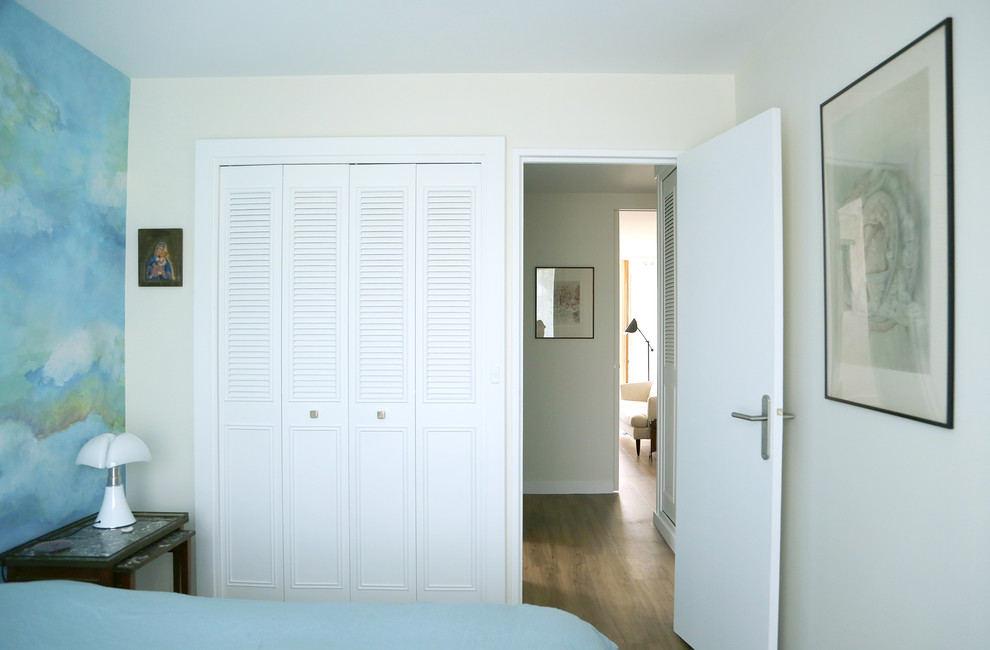 Inspiration pour une chambre parentale design de taille moyenne avec un mur bleu et un sol en bois brun.