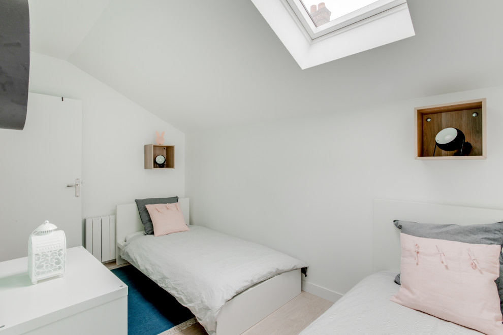 Ejemplo de habitación de invitados escandinava de tamaño medio sin chimenea con paredes blancas, suelo de madera clara y suelo beige
