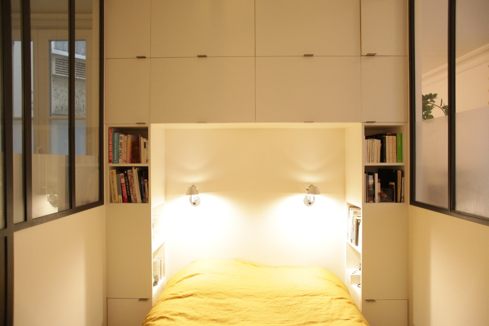Cette image montre une petite chambre parentale design avec un mur blanc, parquet clair et un sol beige.