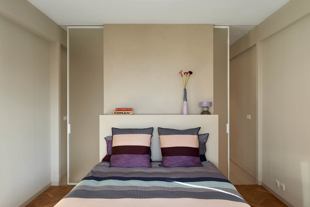 Inspiration pour une petite chambre design avec un mur beige, un sol en bois brun et aucune cheminée.