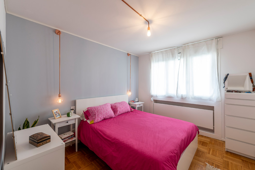 Immagine di una camera da letto bohémian con pareti grigie e pavimento in legno massello medio