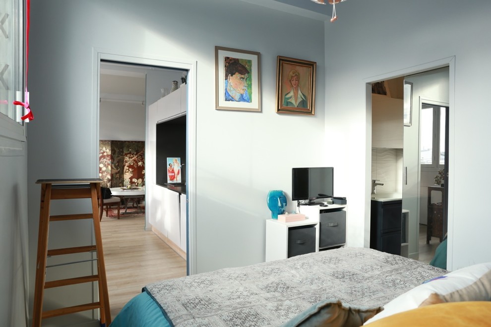 Aménagement d'une petite chambre parentale moderne avec un mur bleu, parquet clair, aucune cheminée et un sol beige.