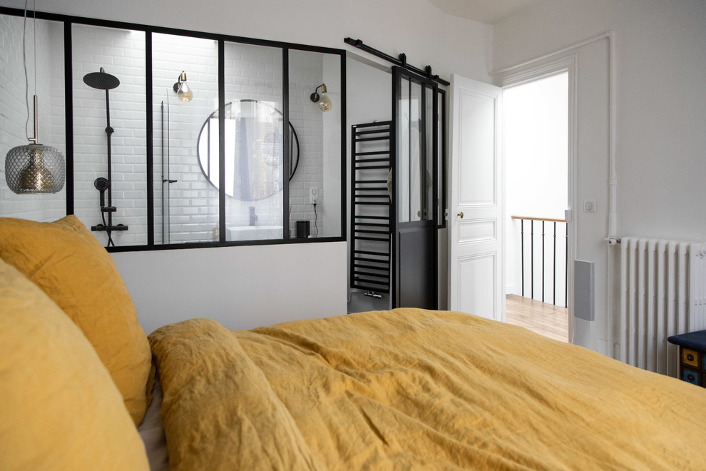 Foto de dormitorio principal urbano de tamaño medio sin chimenea con paredes azules, suelo de madera clara y suelo beige