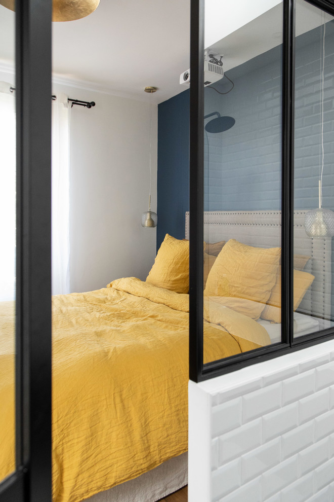 Foto de dormitorio principal urbano de tamaño medio sin chimenea con paredes azules, suelo de madera clara y suelo beige
