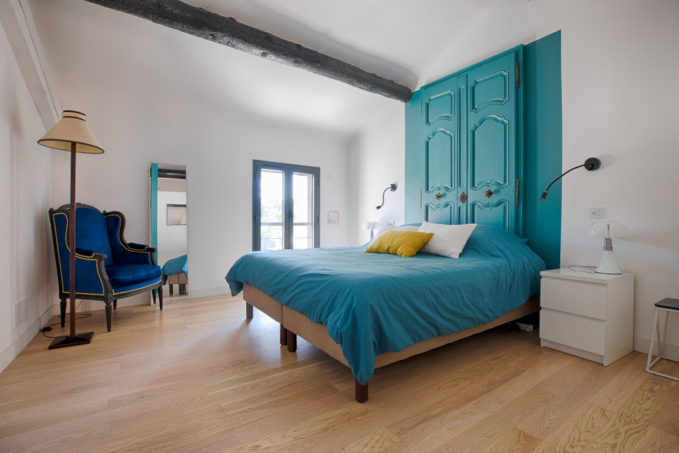 Modelo de dormitorio actual con paredes blancas, suelo de madera clara y suelo beige