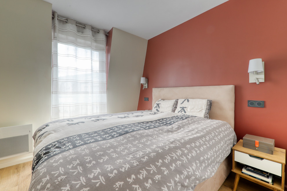 Imagen de dormitorio principal ecléctico con paredes rojas y suelo laminado