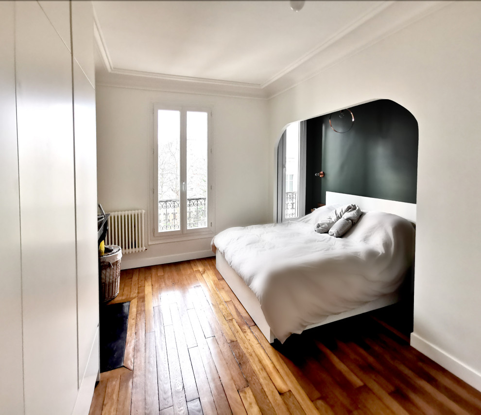 Imagen de dormitorio principal tradicional renovado pequeño con paredes verdes, suelo de madera en tonos medios y todas las chimeneas
