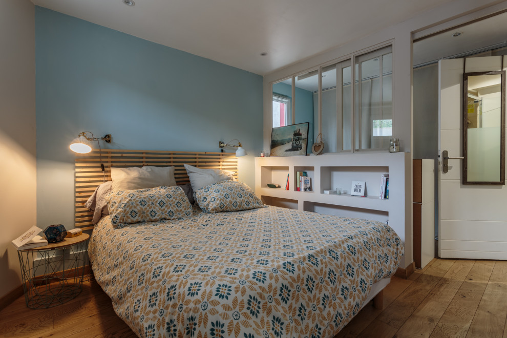 Master medium tone wood floor and brown floor bedroom photo in Bordeaux with blue walls and no fireplace