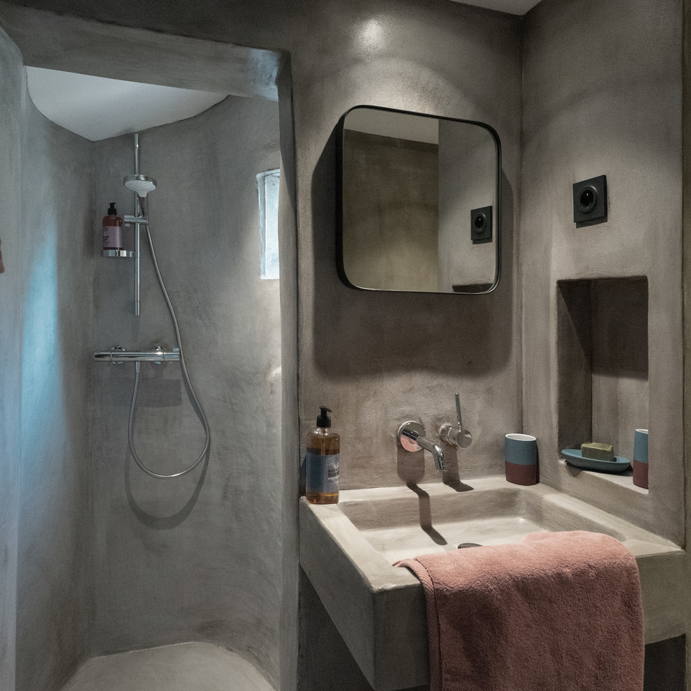 Cette image montre une salle de bain méditerranéenne de taille moyenne avec un lavabo suspendu, aucune cabine, sol en béton ciré et un sol blanc.