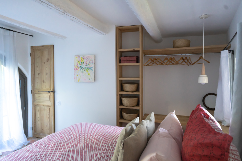 Imagen de dormitorio principal mediterráneo de tamaño medio con suelo de cemento y suelo blanco