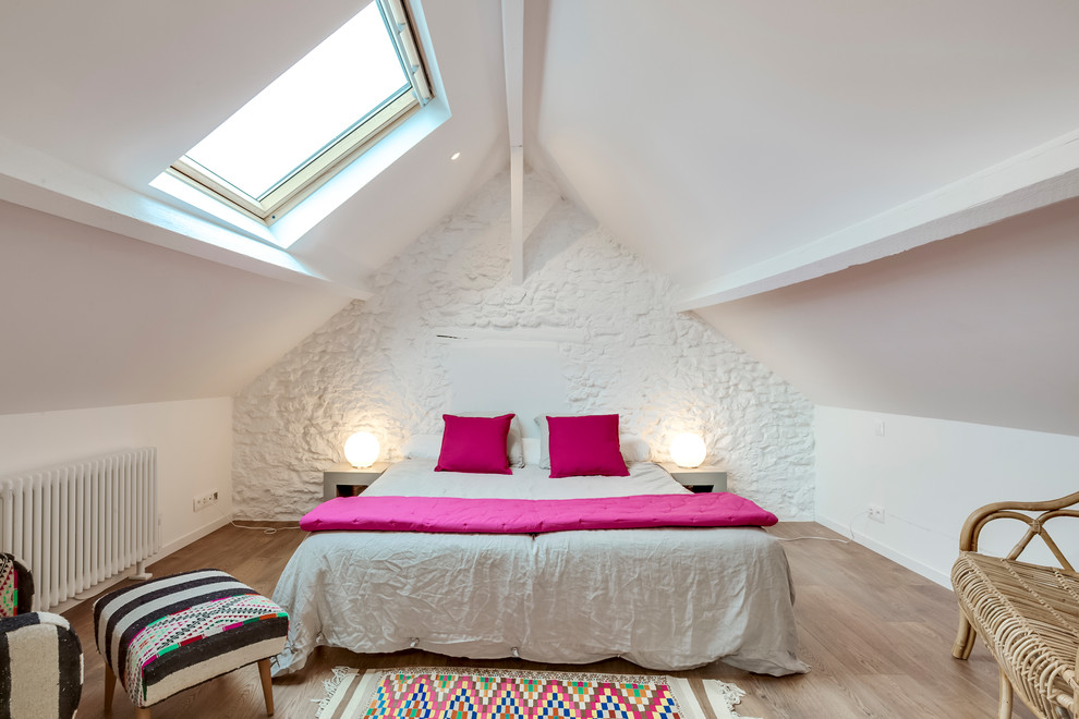 Modelo de dormitorio principal actual de tamaño medio con paredes blancas, suelo marrón y suelo de madera clara