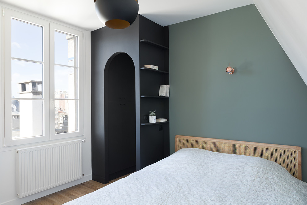 Ejemplo de dormitorio principal exótico pequeño sin chimenea con paredes verdes, suelo de madera clara y suelo beige