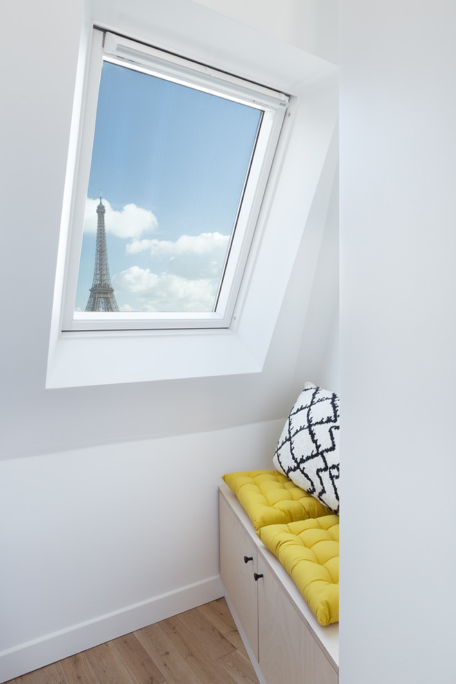 Photo of a small world-inspired master bedroom in Paris with green walls, light hardwood flooring and beige floors.