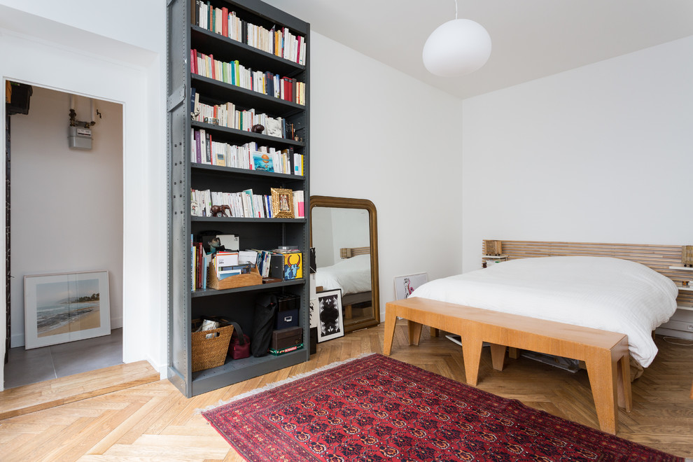 Modelo de dormitorio principal actual de tamaño medio sin chimenea con paredes blancas, suelo de madera en tonos medios y suelo beige