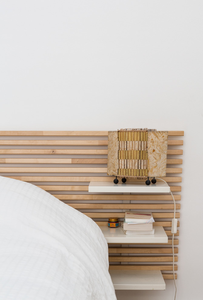Foto de dormitorio principal minimalista de tamaño medio sin chimenea con paredes blancas, suelo de madera en tonos medios y suelo beige