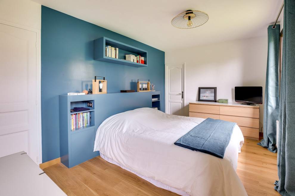 他の地域にあるコンテンポラリースタイルのおしゃれな寝室 (青い壁、無垢フローリング、茶色い床)