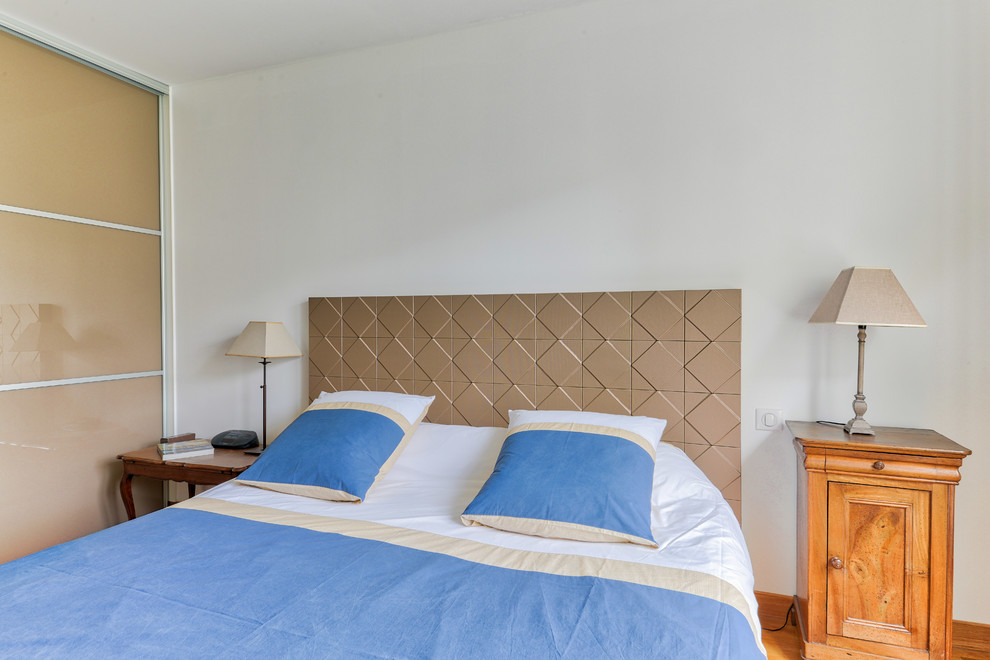 Inspiration for a large classic master bedroom in Paris with white walls, medium hardwood flooring and no fireplace.