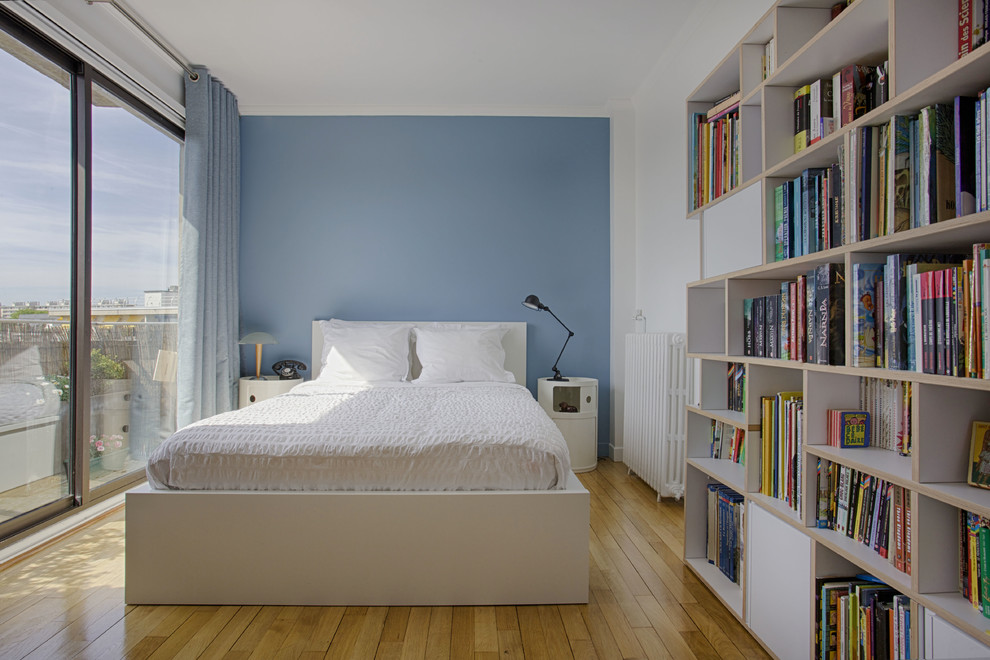 Diseño de dormitorio contemporáneo con paredes azules, suelo de madera en tonos medios y suelo marrón