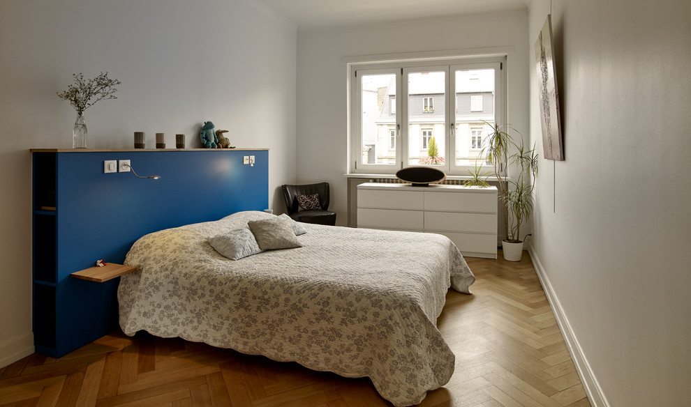 Cette image montre une chambre d'amis nordique de taille moyenne avec un mur blanc, parquet clair et un sol beige.