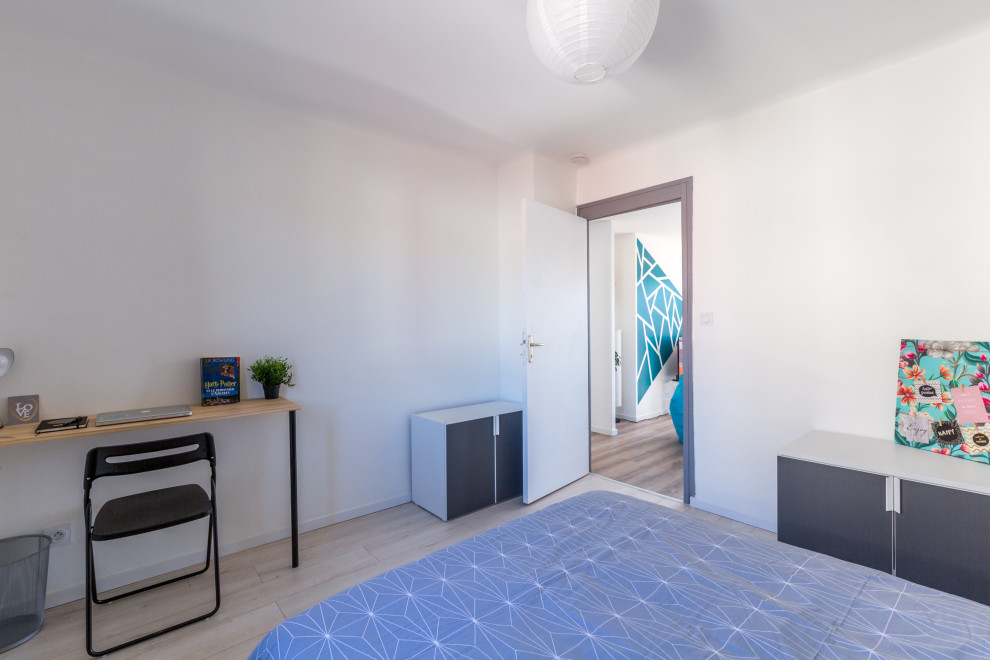 Immagine di una camera da letto contemporanea di medie dimensioni con pavimento in laminato e pareti bianche