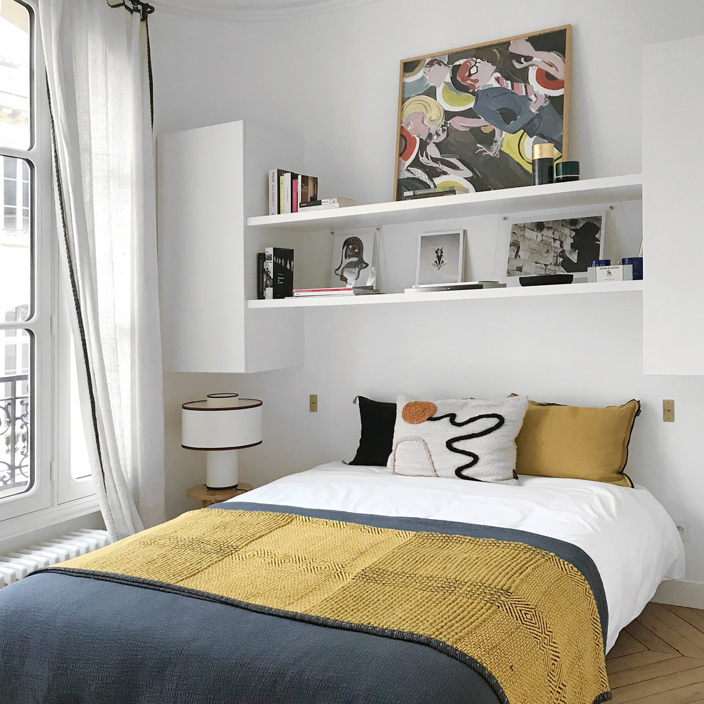 Design ideas for a contemporary bedroom in Paris with white walls, light hardwood flooring, no fireplace and feature lighting.