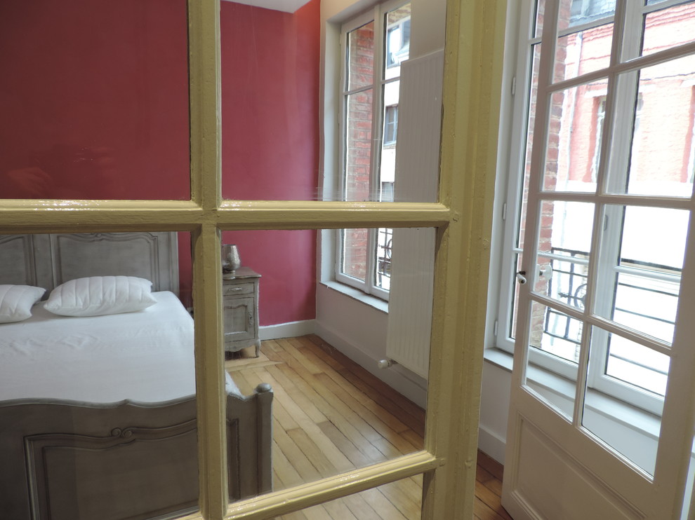 Cette image montre une chambre parentale minimaliste de taille moyenne avec un mur rose et parquet clair.