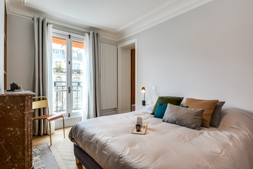 На фото: хозяйская спальня среднего размера в стиле фьюжн с серыми стенами и светлым паркетным полом