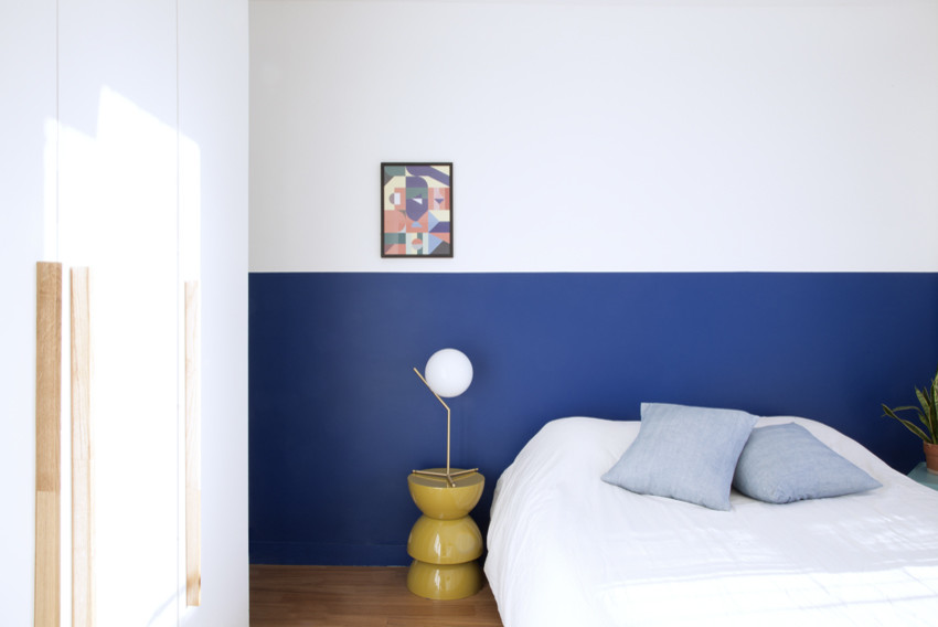 Exemple d'une chambre parentale tendance de taille moyenne avec un mur bleu, un sol en bois brun, aucune cheminée et un sol marron.