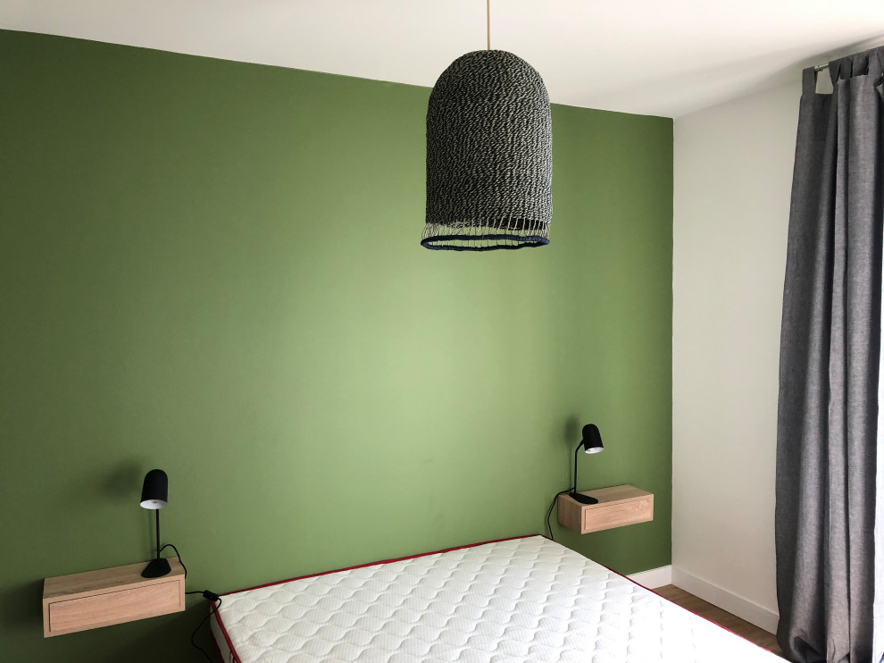 Foto de dormitorio moderno de tamaño medio con paredes verdes y suelo de madera clara