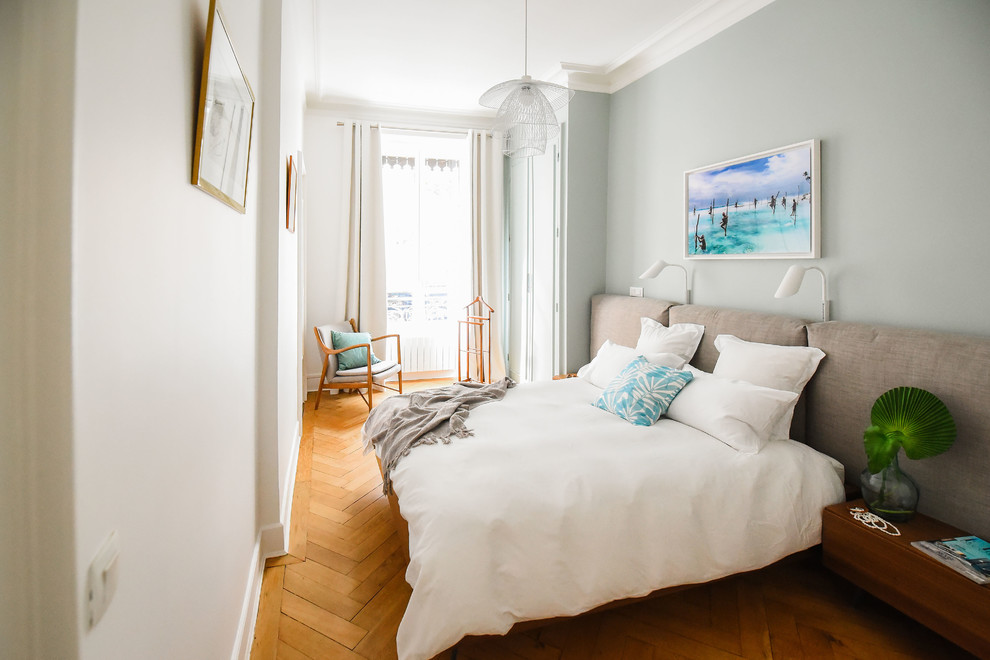 Ejemplo de dormitorio principal actual de tamaño medio con paredes verdes, suelo de madera clara y suelo marrón