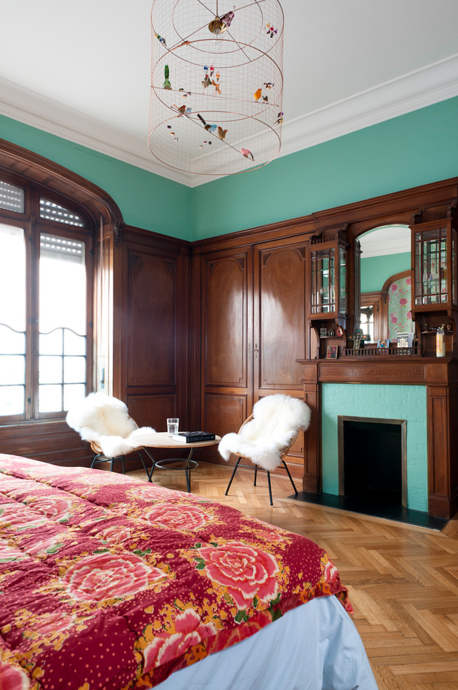 Großes Rustikales Hauptschlafzimmer mit grüner Wandfarbe, braunem Holzboden, Kamin und Kaminumrandung aus Backstein in Bordeaux