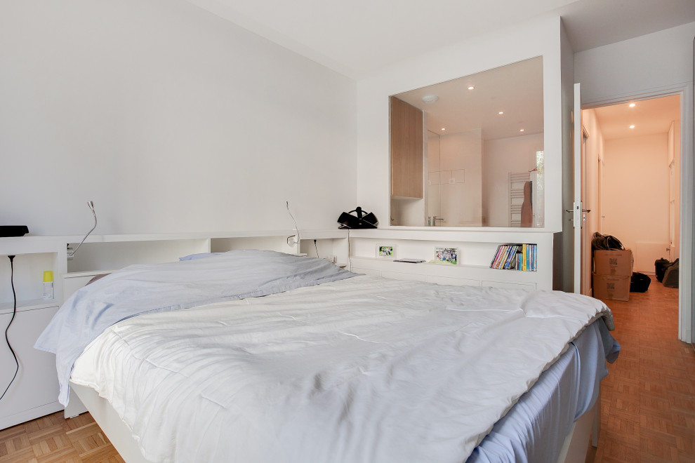 На фото: хозяйская спальня среднего размера в скандинавском стиле с белыми стенами, светлым паркетным полом и многоуровневым потолком с