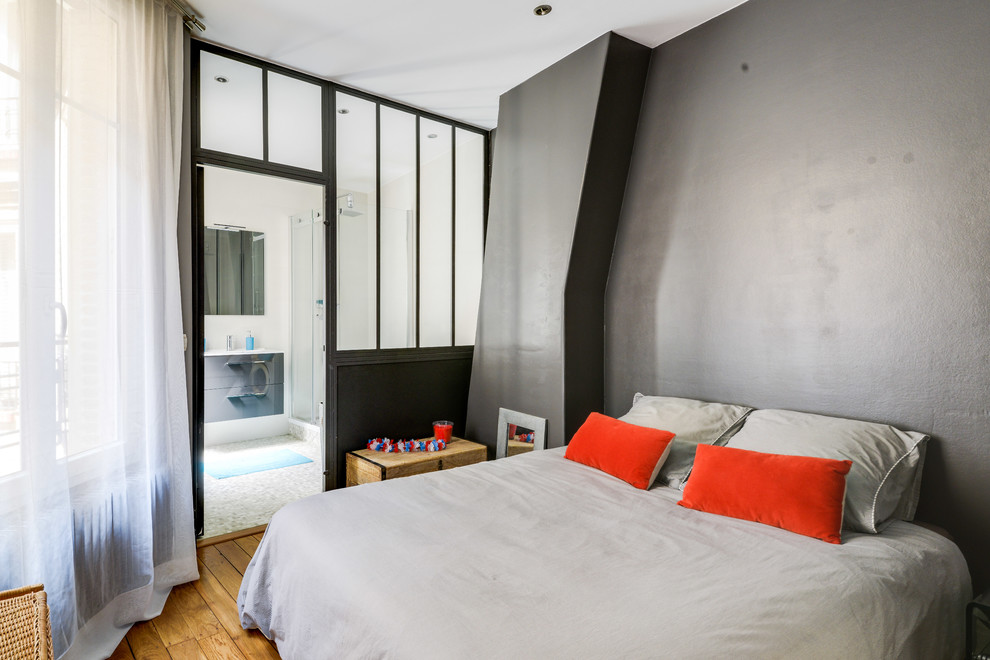 Foto di una camera matrimoniale design con pareti grigie, pavimento in legno massello medio e pavimento marrone