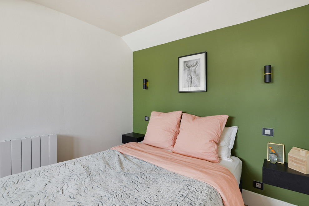 Diseño de dormitorio principal nórdico de tamaño medio sin chimenea con paredes verdes, suelo de madera clara y suelo marrón