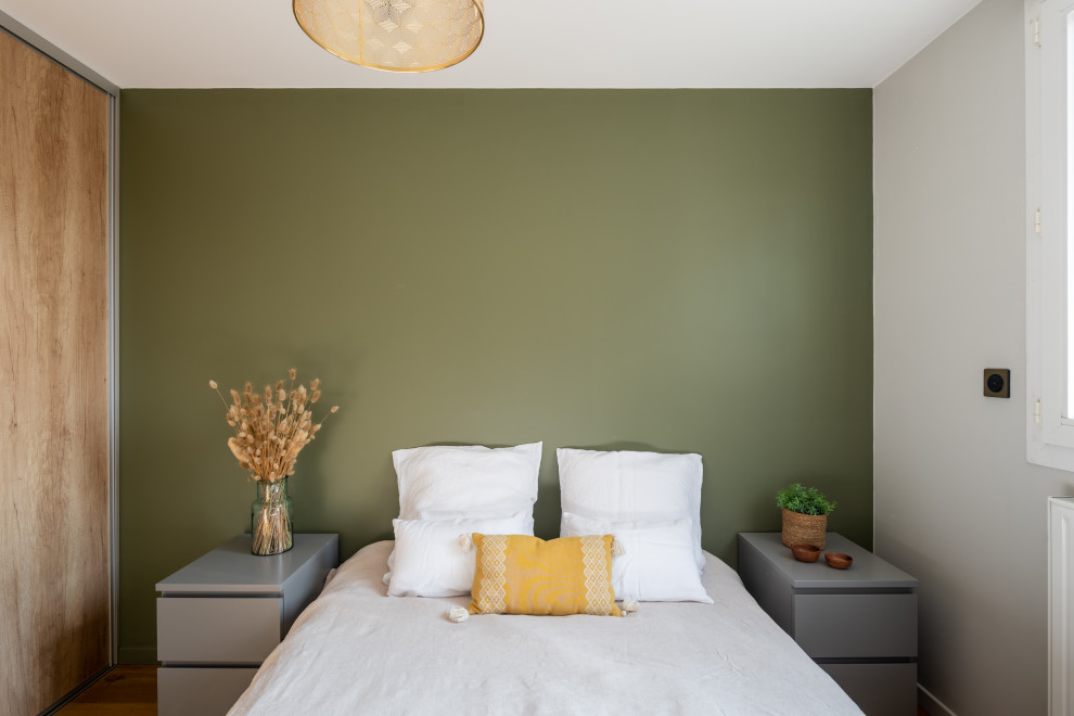 Foto de habitación de invitados escandinava de tamaño medio sin chimenea con paredes verdes y suelo de madera clara