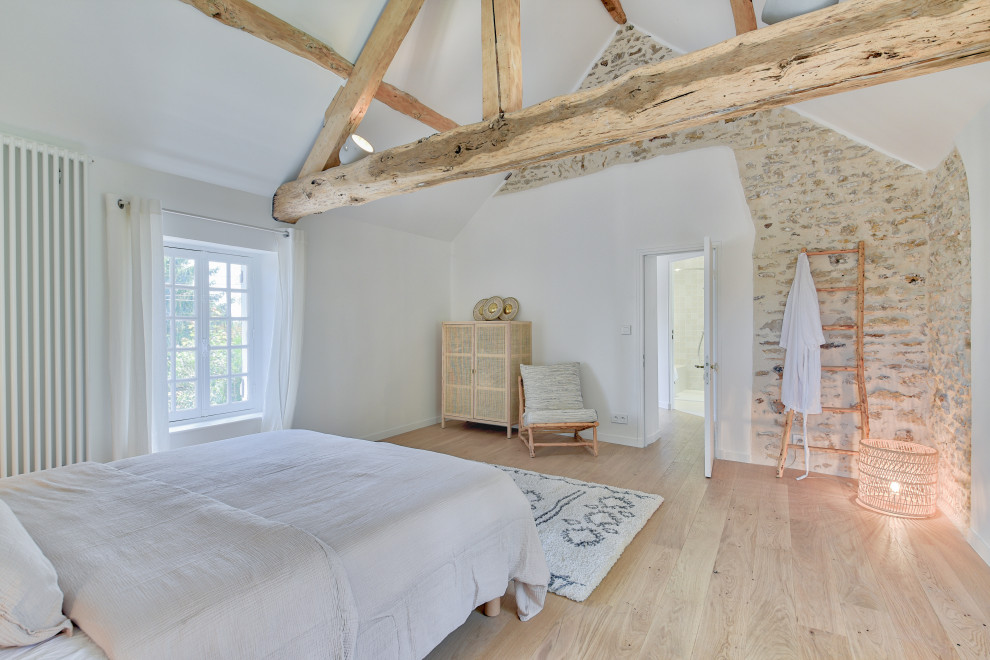 Foto de dormitorio abovedado de estilo de casa de campo con paredes blancas, suelo de madera clara, suelo beige y vigas vistas
