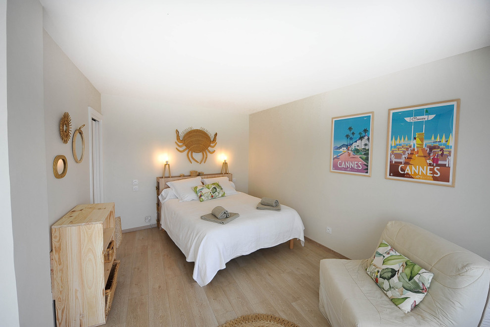 ニースにある広いビーチスタイルのおしゃれな主寝室 (ベージュの壁、淡色無垢フローリング、ベージュの床、暖炉なし) のインテリア