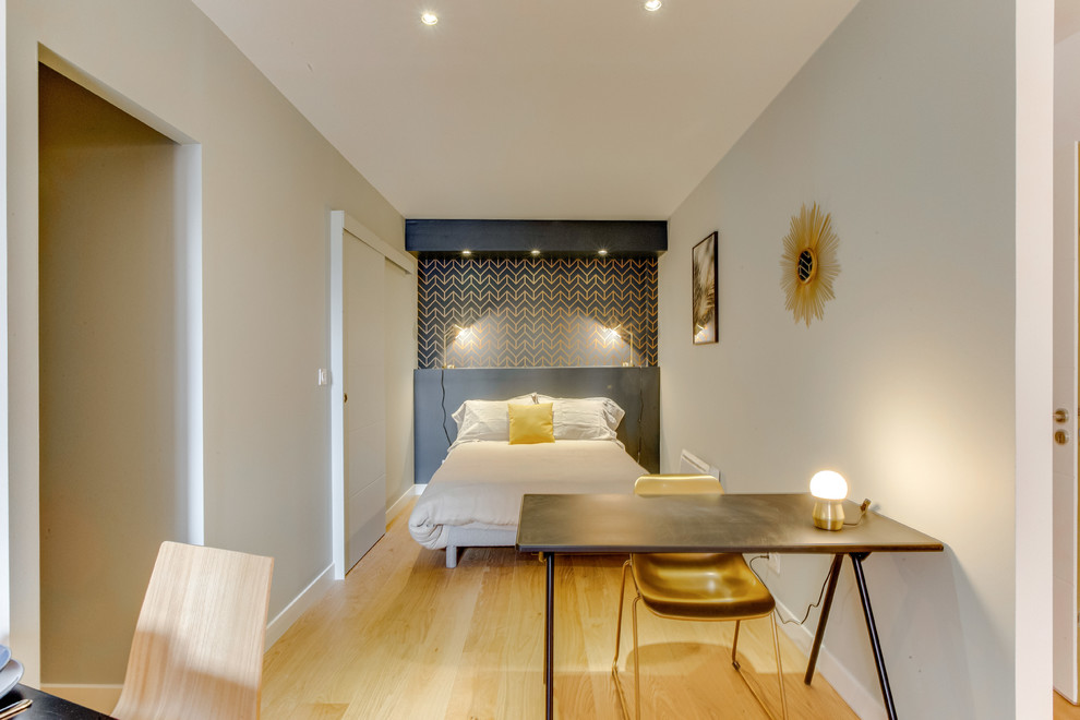 Inspiration för små moderna sovrum, med orange väggar och ljust trägolv