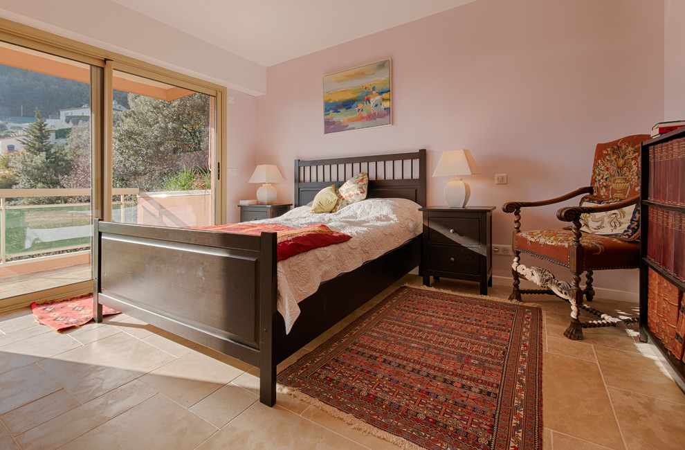Réalisation d'une grande chambre parentale champêtre avec un mur rose, un sol en calcaire, un poêle à bois et un manteau de cheminée en métal.