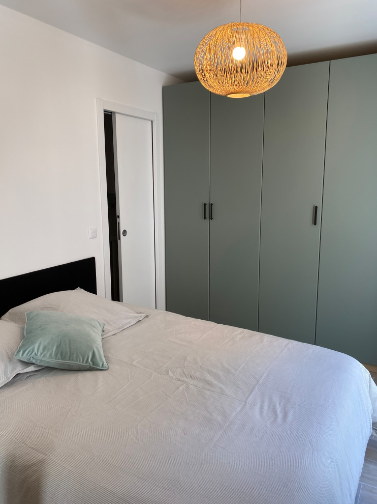 Ejemplo de dormitorio contemporáneo pequeño con paredes blancas, suelo de baldosas de cerámica, suelo beige y vigas vistas