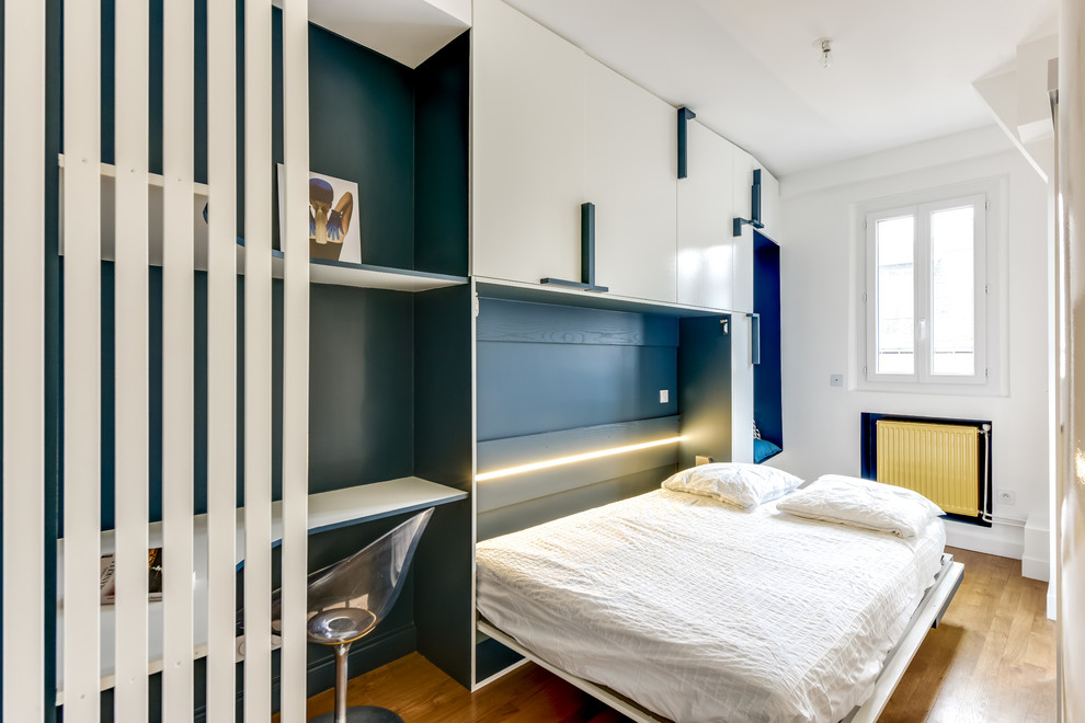 Imagen de dormitorio principal actual pequeño con paredes blancas y suelo de madera en tonos medios