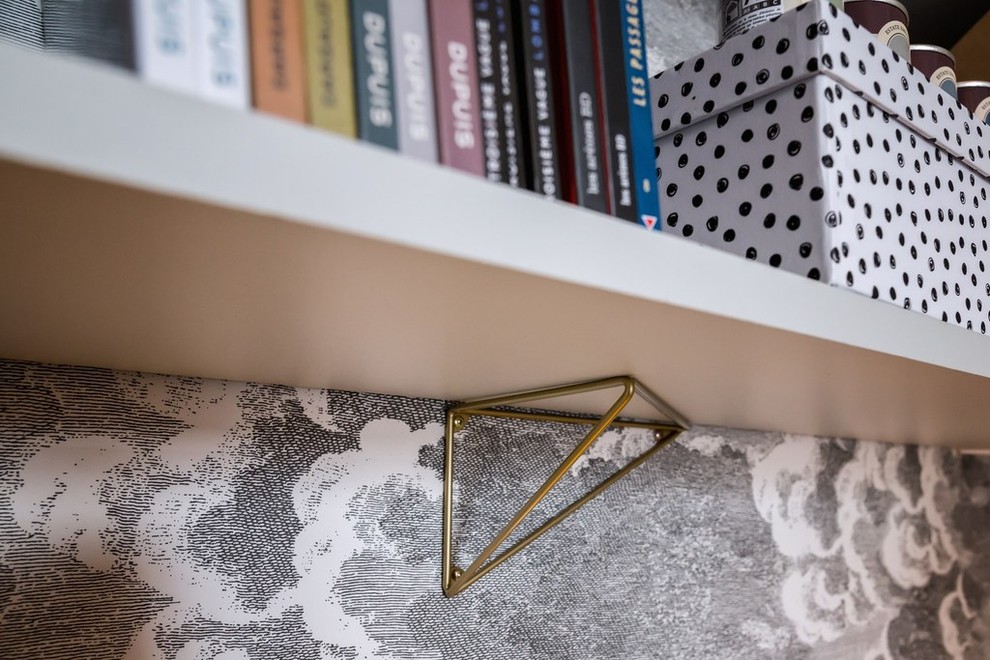 Aménagement d'une grande chambre parentale contemporaine avec un mur gris, parquet clair, une cheminée d'angle, un manteau de cheminée en pierre et un sol marron.