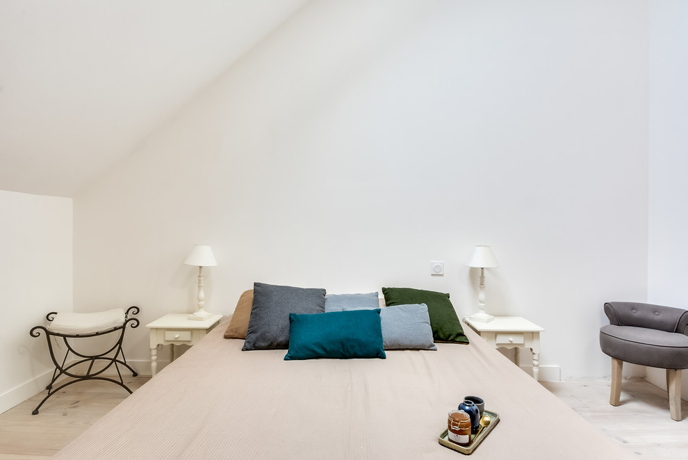 Cette photo montre une grande chambre parentale éclectique avec un mur blanc, parquet clair et un sol blanc.