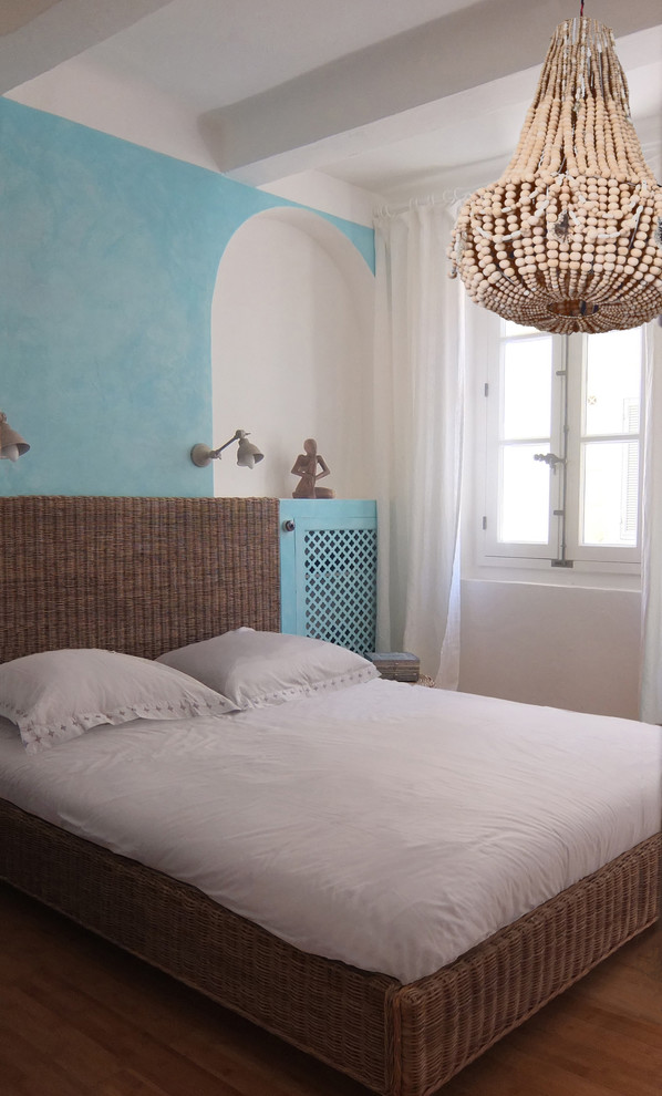 マルセイユにある中くらいな地中海スタイルのおしゃれな客用寝室 (青い壁、無垢フローリング) のレイアウト